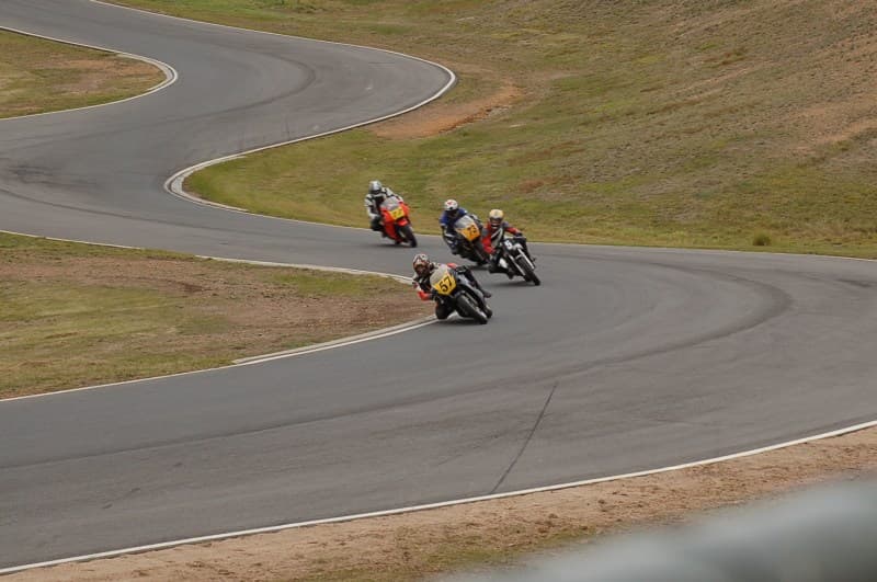 Motorcycle racers cornering through an esses section on the track at Broadford Motorcycle Complex, Victoria, Australia