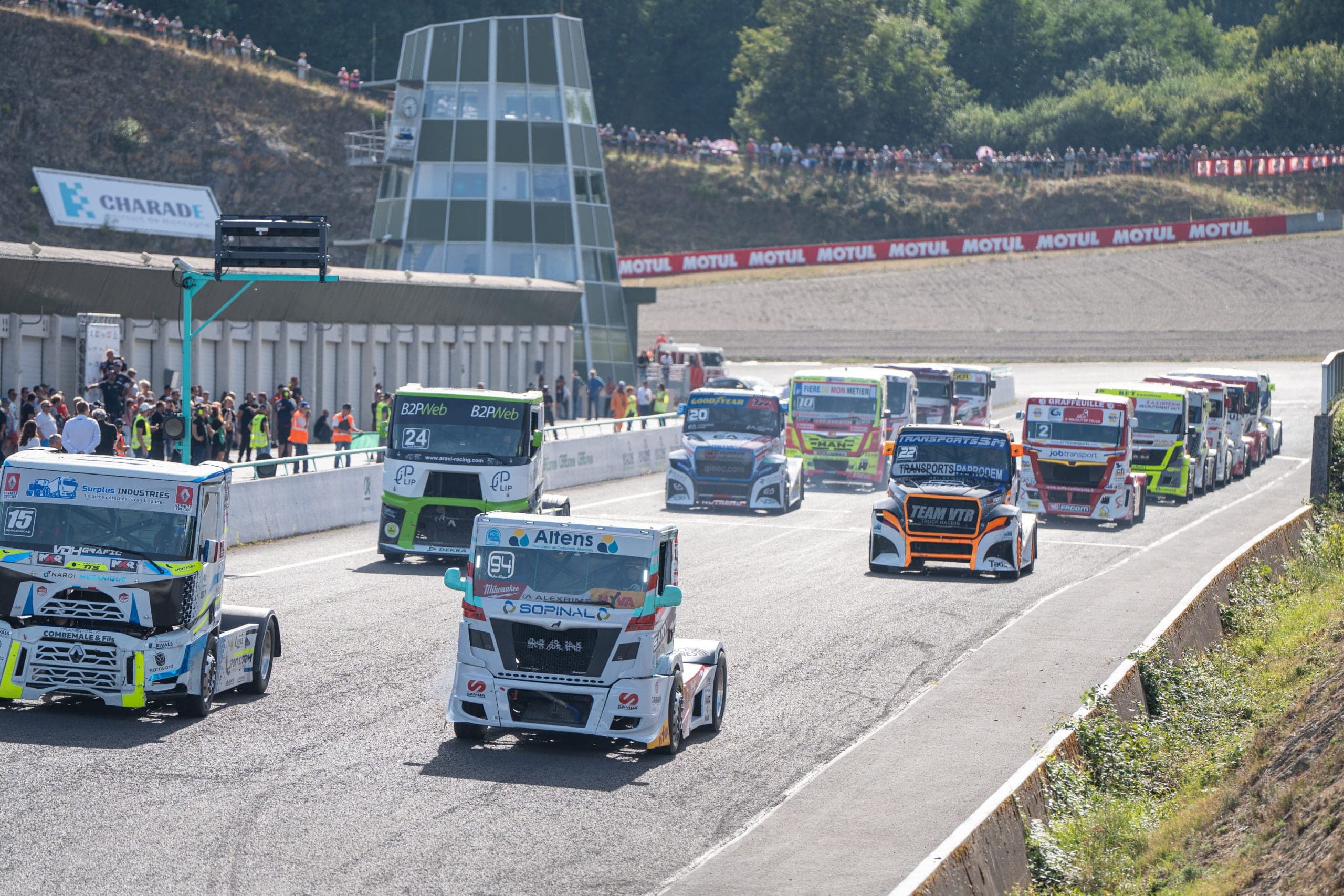 Race trucks line up on the grid beneath the Charade control tower before an ETRC round