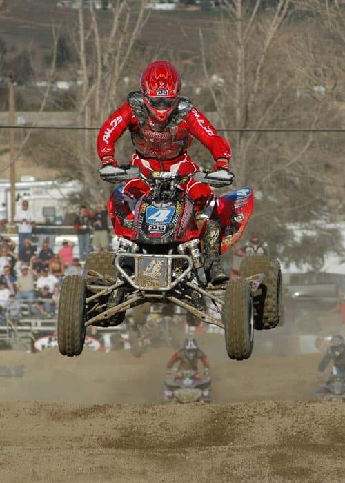 ATV racer launching high off a dirt jump at Glen Helen GNC MX National, Rialto, California, 2006